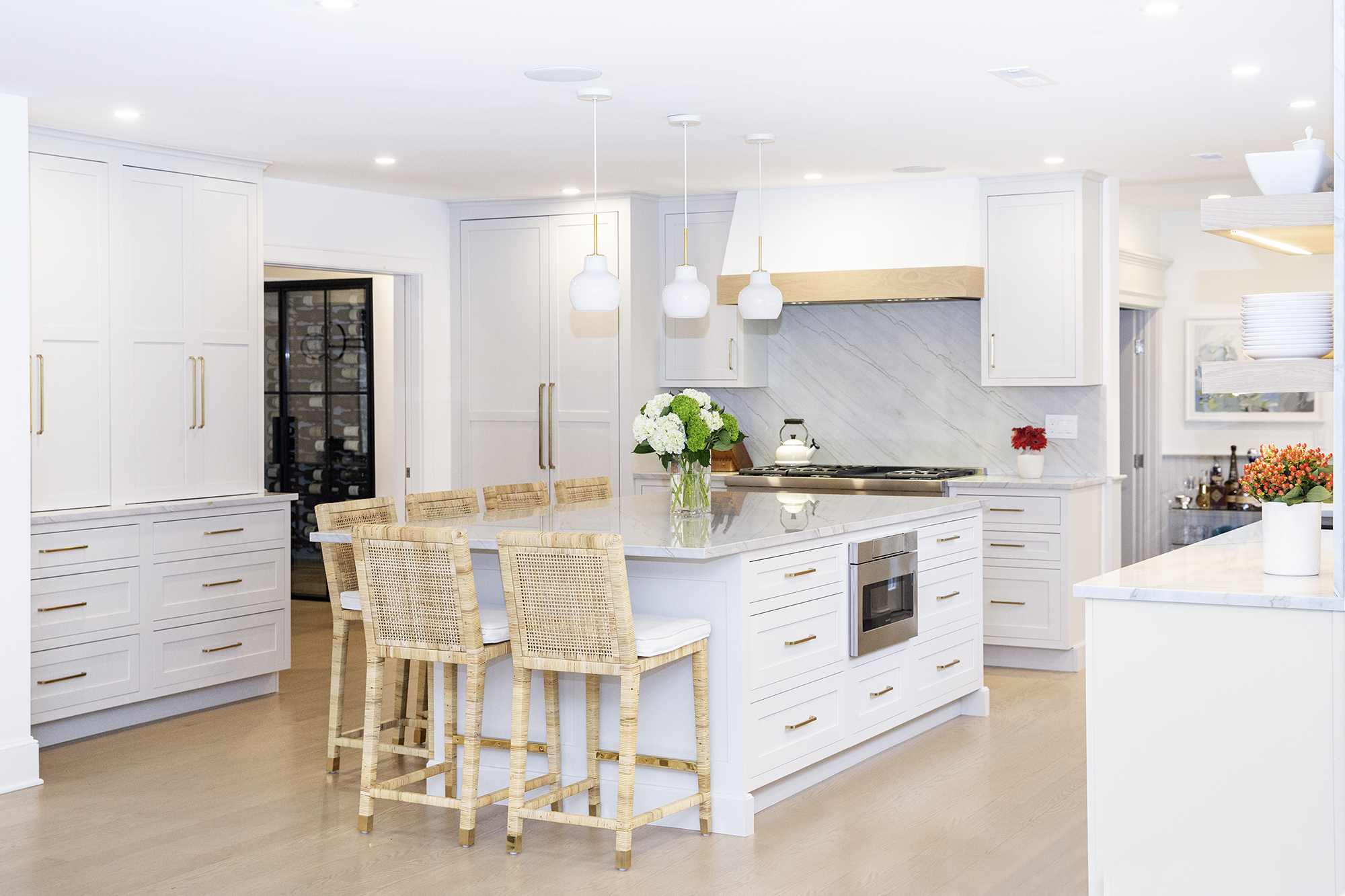 Clean and open kitchen design with white cabinets and walls and wooden accents.